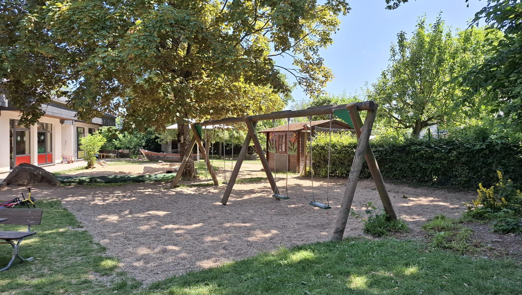 Man sieht das Außengelände mit einer Schaukel im Schatten (c) Katholische KiTa gGmbH Trier Man sieht das Außengelände mit einer Schaukel im Schatten