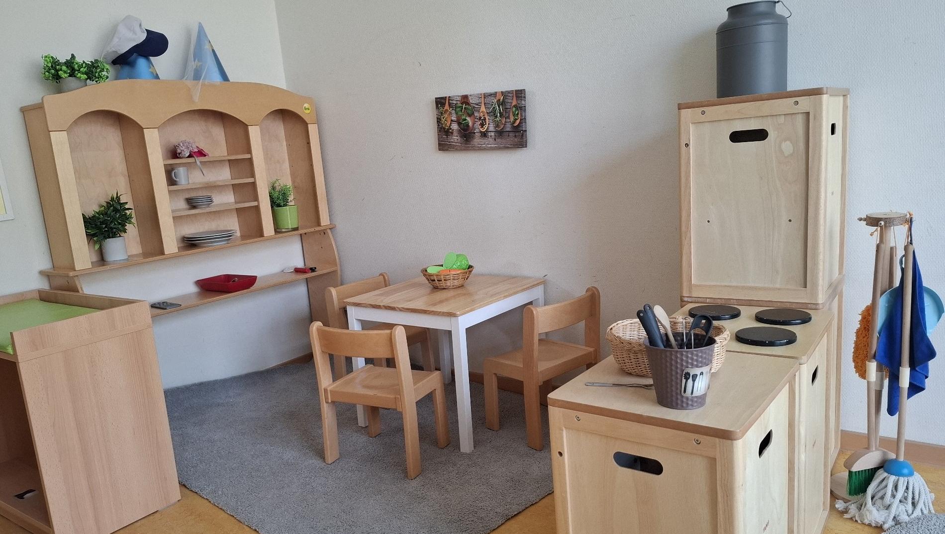 Man sieht eine Spielküche mit Essbereich der KiTa