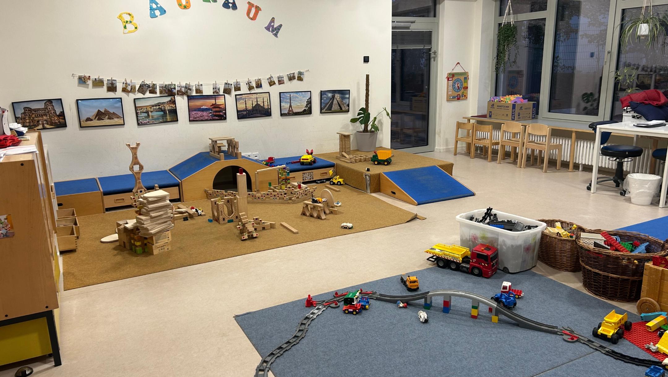 Man sieht den Bauraum mit Bauklötzen und einer Eisenbahn